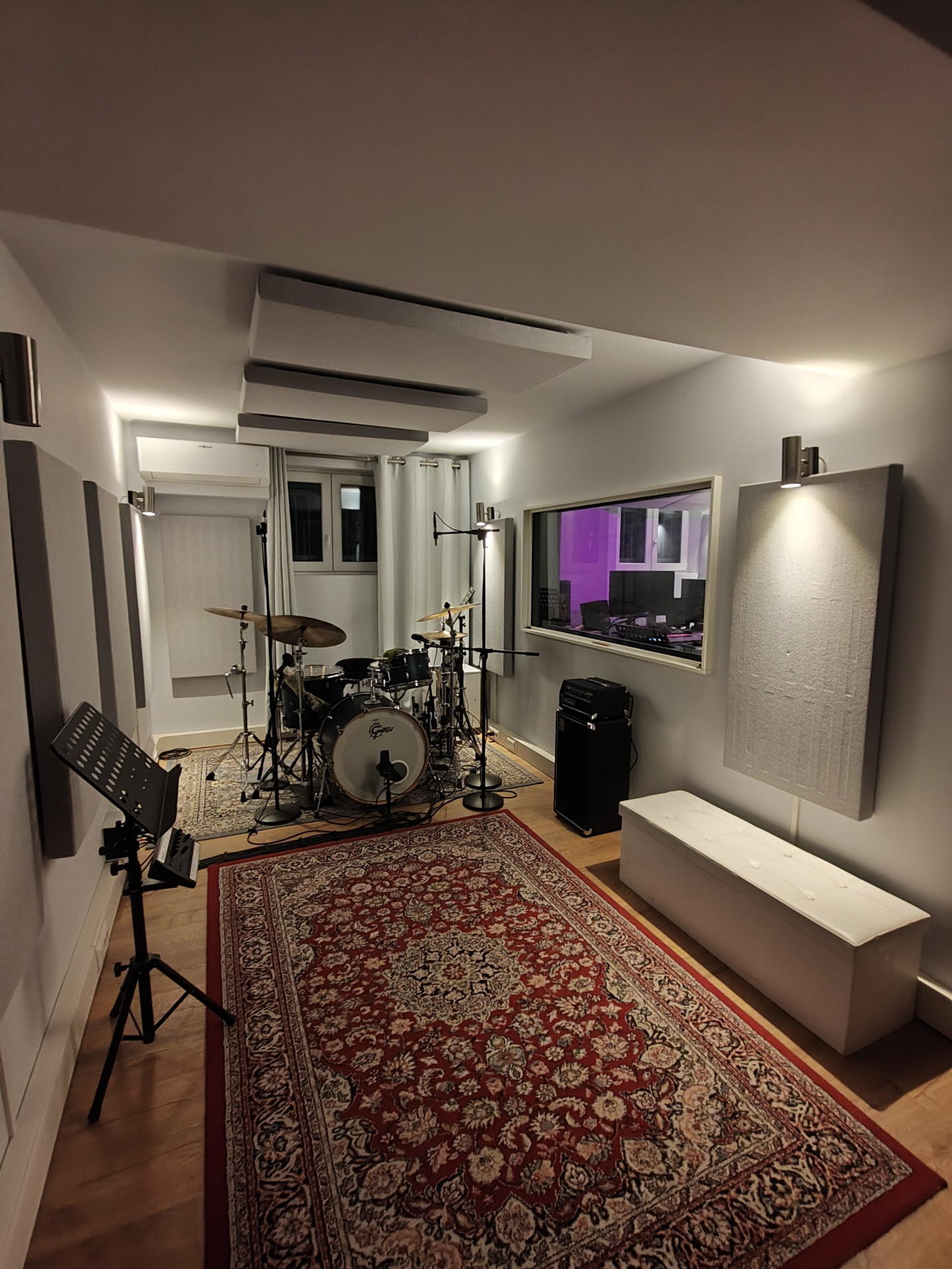 Live room con batteria microfonata e vetro verso la regia